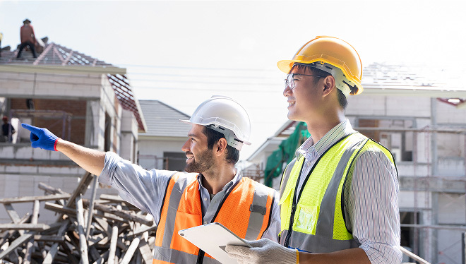 Construction business owners and operators discussing commercial building envelope solutions at a job site